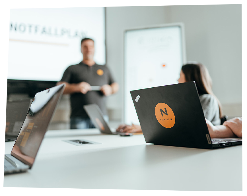 Quadratisches Foto einer internen Schulung mit Neininger Laptop auf dem Konferenztisch.